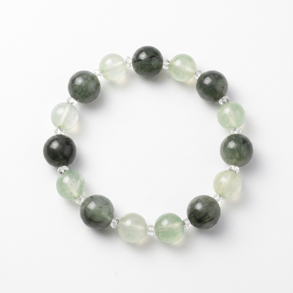 Krysora Verdant Radiance — green rutilated quartz and prehnite beads, sprouting sage green on white.