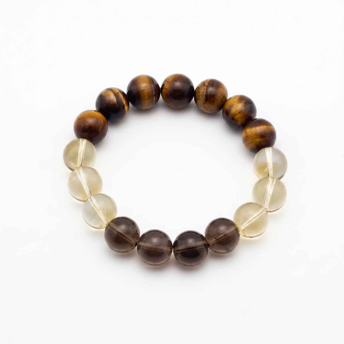 Krysora Bedrock — warm ochre and smoky quartz beads, clay-toned gold and gray on white.