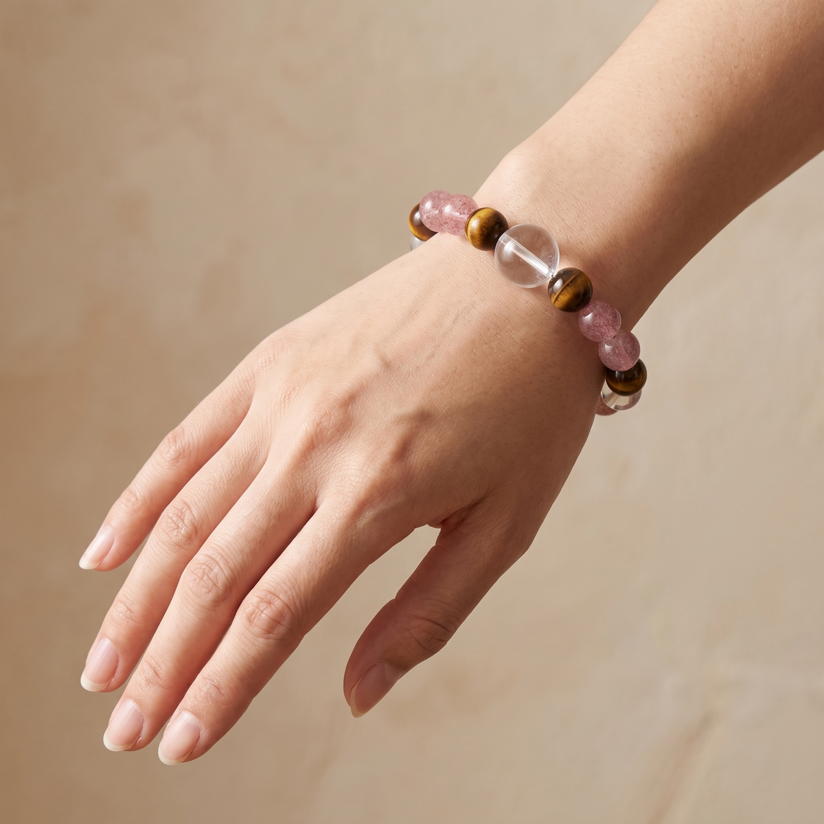 Tawny Blush bracelet by Krysora worn on a woman's wrist - warm tiger's eye with soft strawberry pink