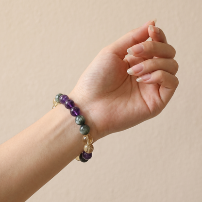 Verdant Flame bracelet by Krysora worn on a woman's wrist - spring green rutilated quartz with honey gold citrine and soft violet amethyst