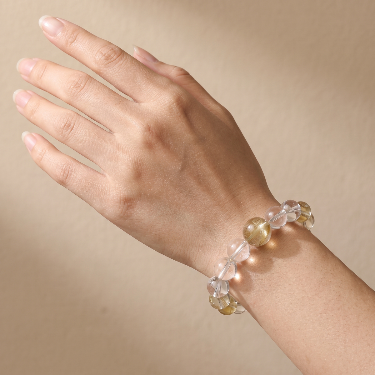 Gilded Radiance bracelet by Krysora worn on a woman's wrist - warm champagne gold and warm clay beads