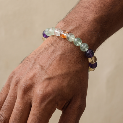 Tri-Cultivate bracelet by Krysora worn on a man's wrist - warm red, honey gold and soft green gemstones