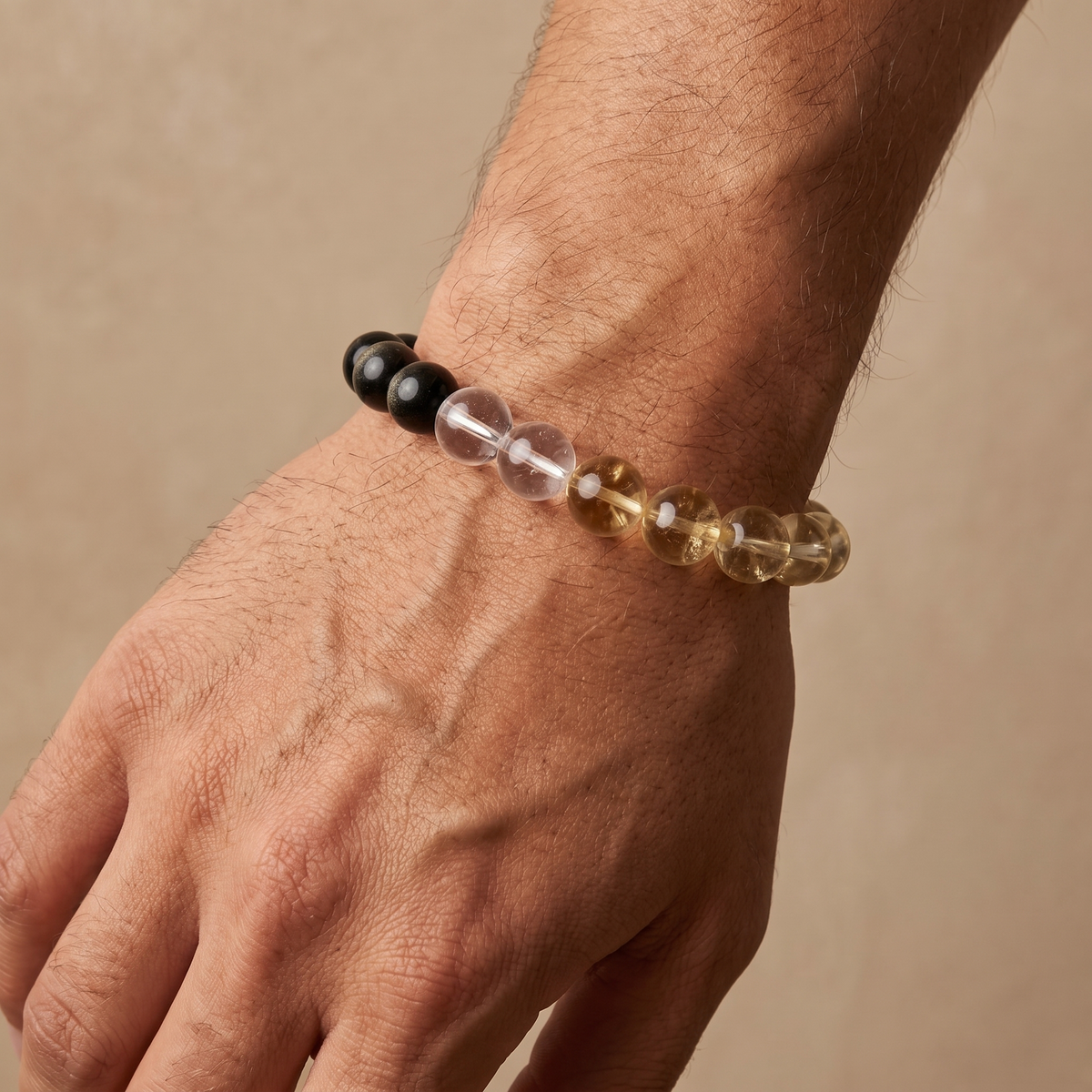 Terra Gold bracelet by Krysora worn on a man's wrist - dark gold-sheen obsidian with honey gold citrine and clear white quartz