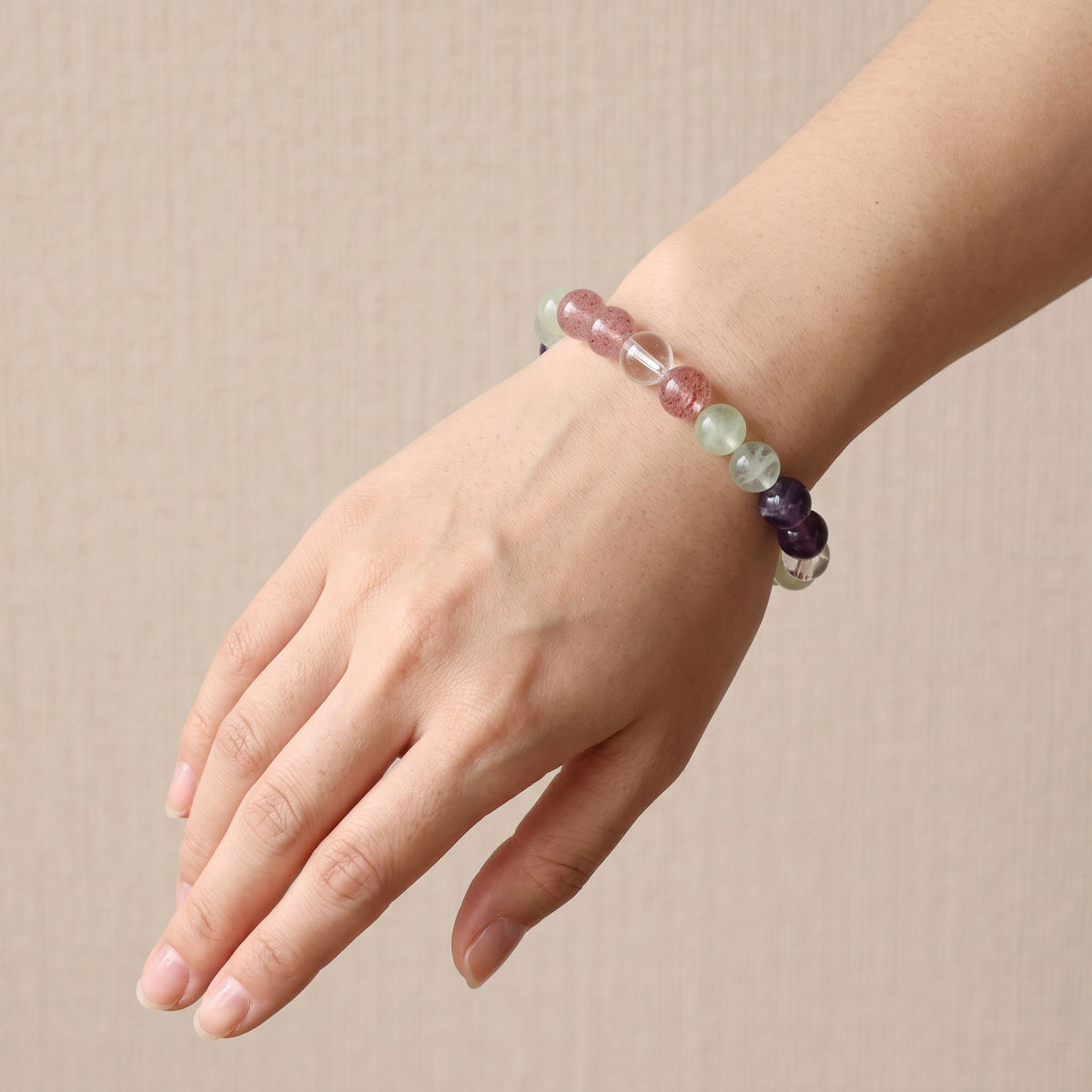 Verdant Blush bracelet by Krysora worn on a woman's wrist - verdant green prehnite with pink-red strawberry quartz