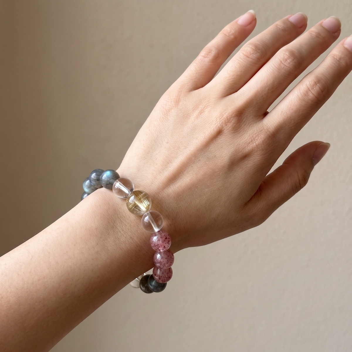 Gilded Blush bracelet by Krysora worn on a woman's wrist - warm golden rutilated quartz with soft pink strawberry quartz