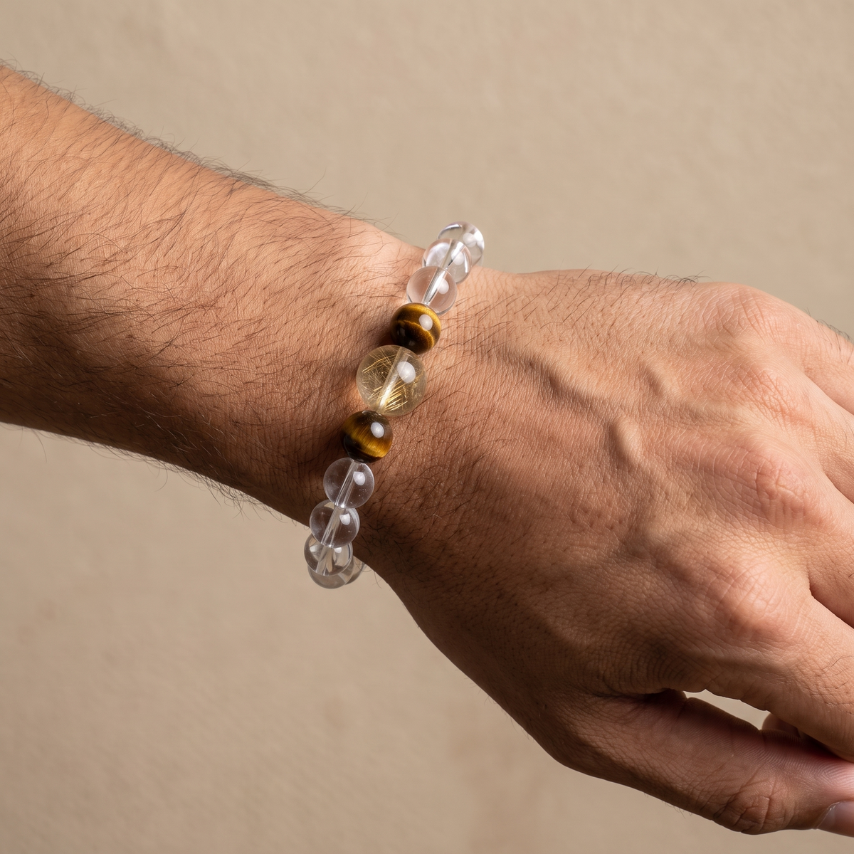 Gilded Silk bracelet by Krysora worn on a man's wrist - champagne gold and warm clay beads with soft silk-white rutile