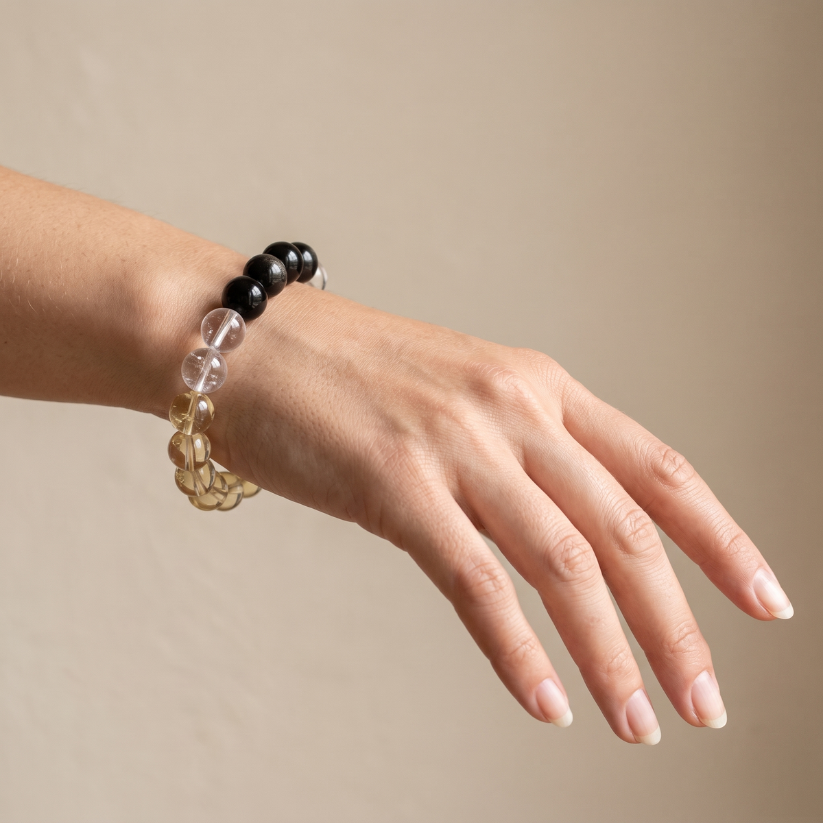 Terra Gold bracelet by Krysora worn on a woman's wrist - dark gold-sheen obsidian with honey gold citrine and clear white quartz