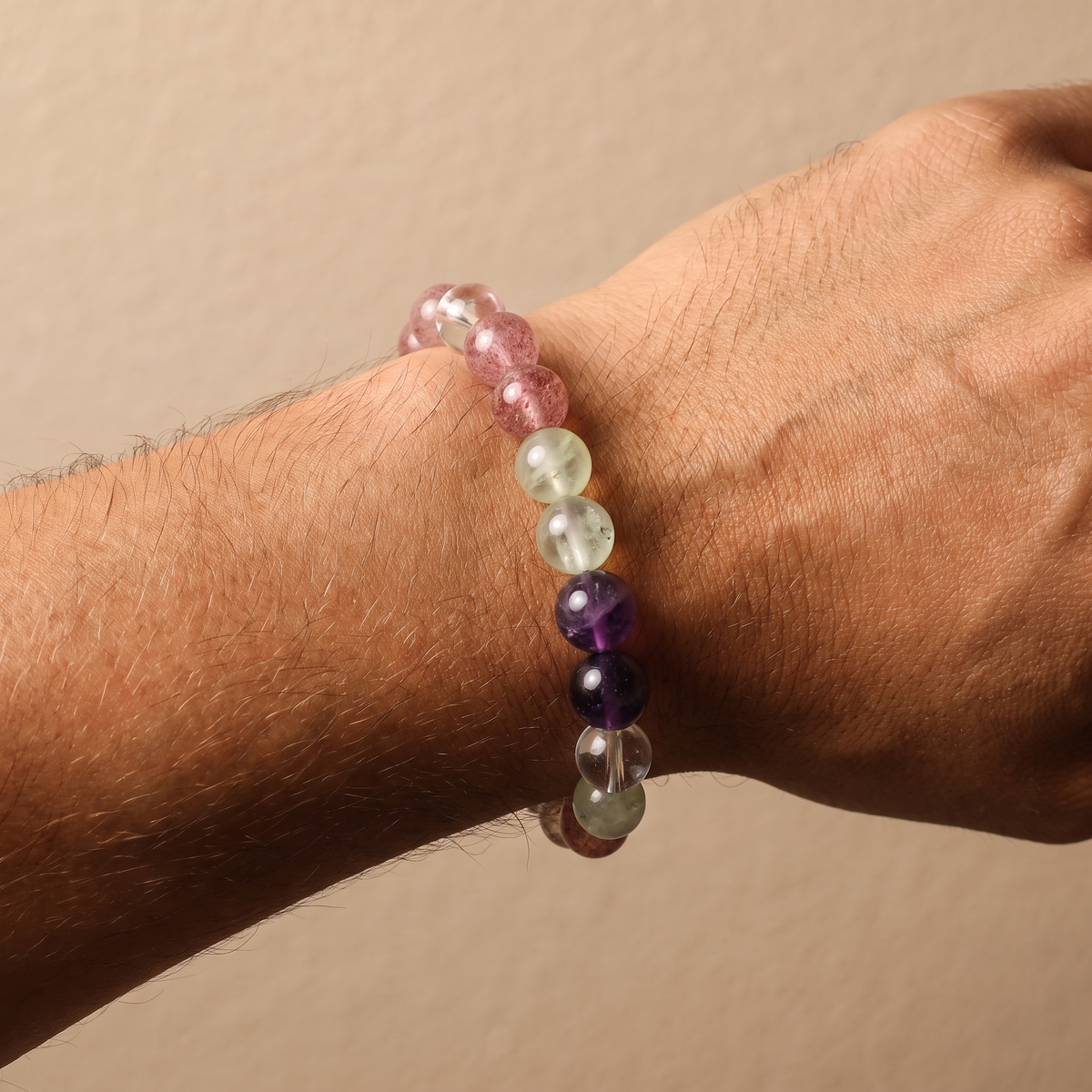 Verdant Blush bracelet by Krysora worn on a man's wrist - verdant green prehnite with pink-red strawberry quartz