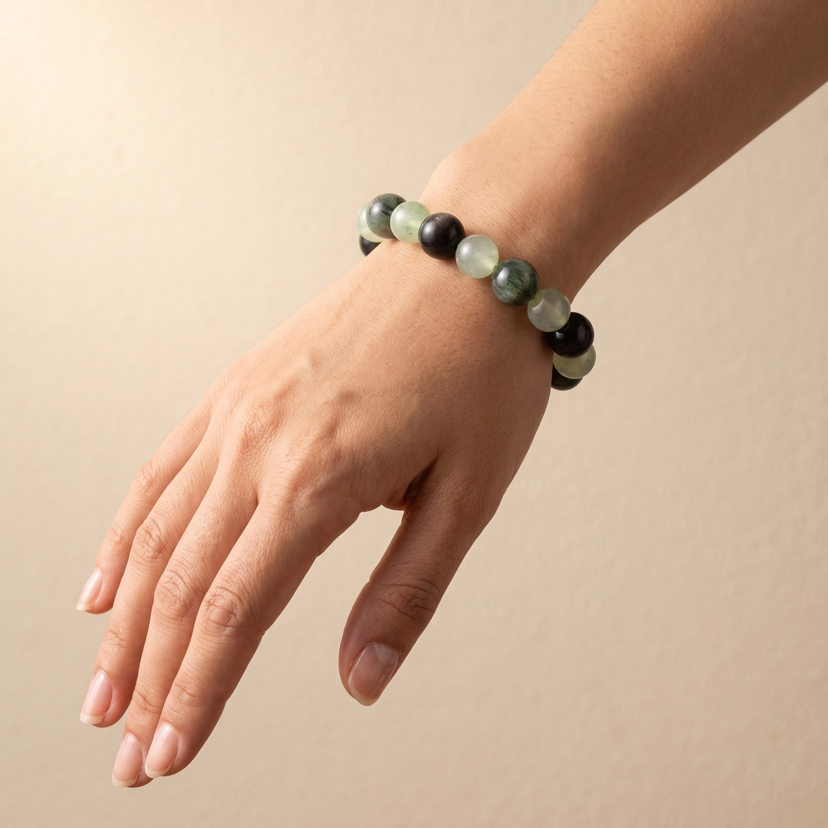 Aqua Verdance bracelet by Krysora worn on a woman's wrist - cool ink and fresh sage beads with silver sheen