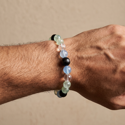 Confluence bracelet by Krysora worn on a man's wrist - deep blue-black obsidian with blue-green aquamarine