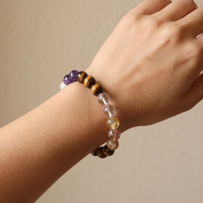 Ember Gold bracelet by Krysora worn on a woman's wrist - golden-brown tiger's eye with warm red hematoid glow