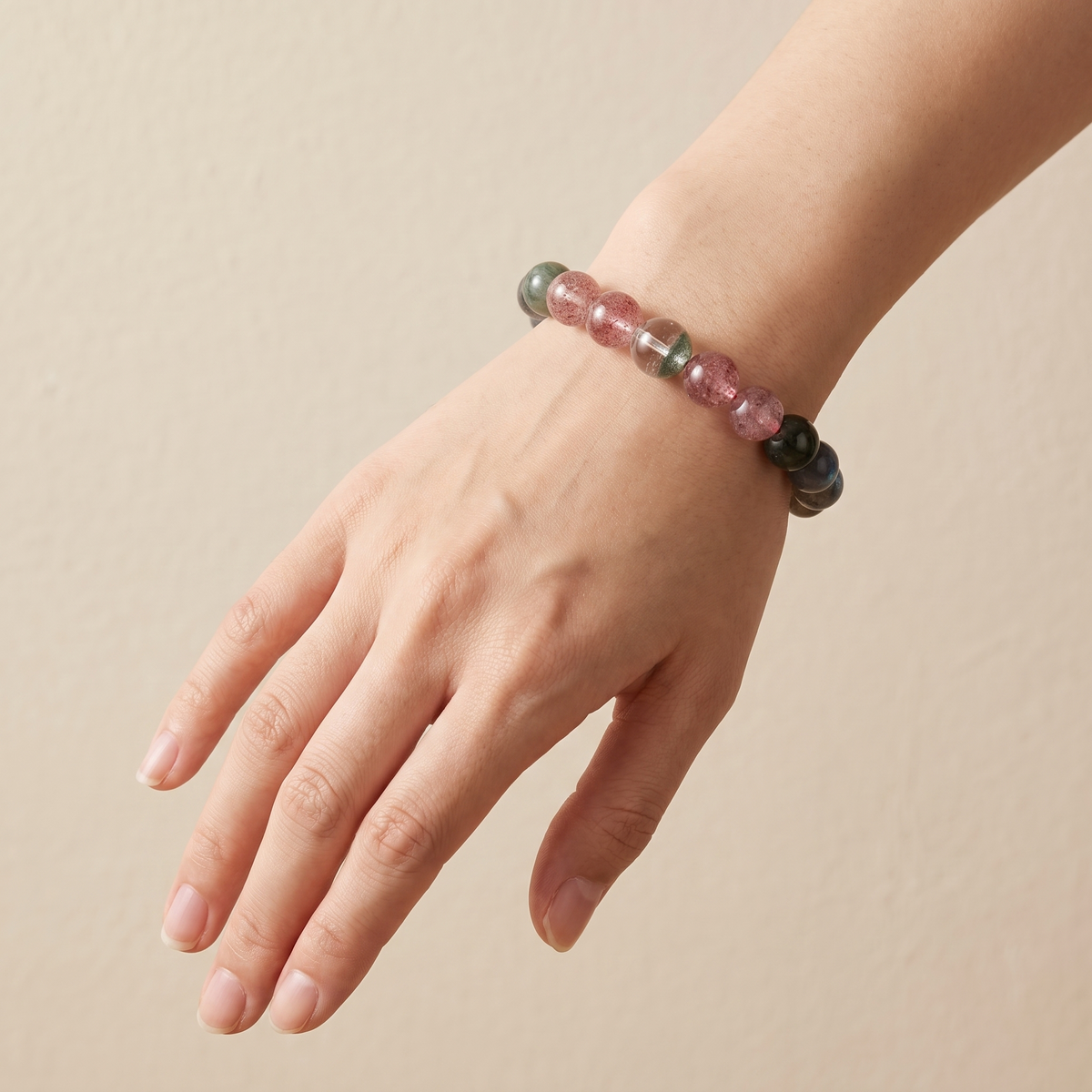 Verdant Bloom bracelet by Krysora worn on a woman's wrist - clear green phantom and rutilated quartz with berry pink strawberry quartz