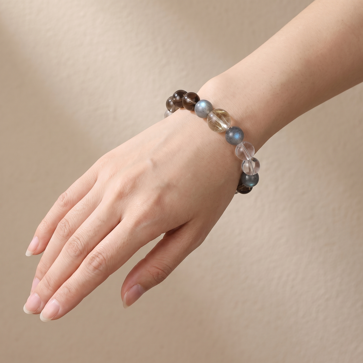 Aurum Haze bracelet by Krysora worn on a woman's wrist - warm golden rutilated quartz with soft smoky brown