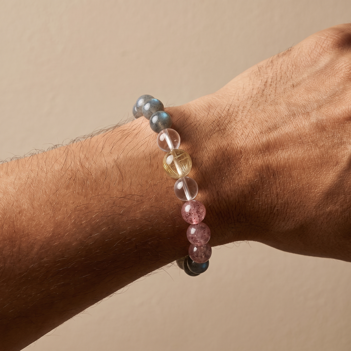 Gilded Blush bracelet by Krysora worn on a man's wrist - warm golden rutilated quartz with soft pink strawberry quartz