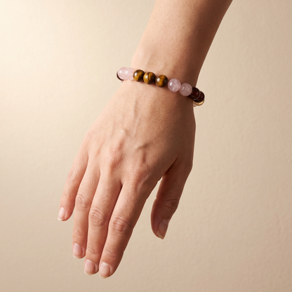Ember Bloom bracelet by Krysora worn on a woman's wrist - soft pink, golden-brown, warm red and bright yellow beads