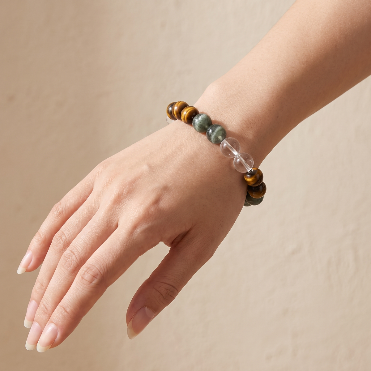 Verdant Bronze bracelet by Krysora worn on a woman's wrist - verdant green rutilated quartz with golden-brown tiger's eye