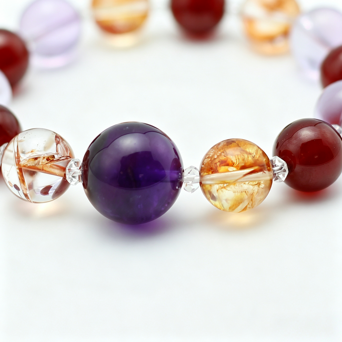 Southern Flame bead detail — amethyst, garnet and red hematoid quartz, natural markings up close.