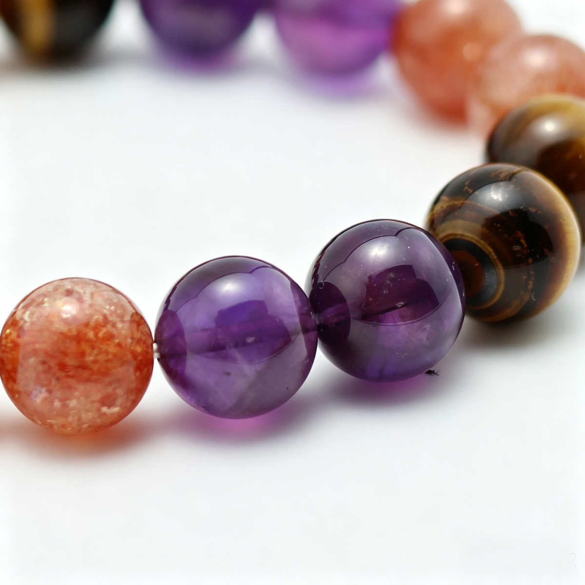 Solar Blaze bead detail — amethyst, golden sunstone and tiger's eye, natural markings up close.