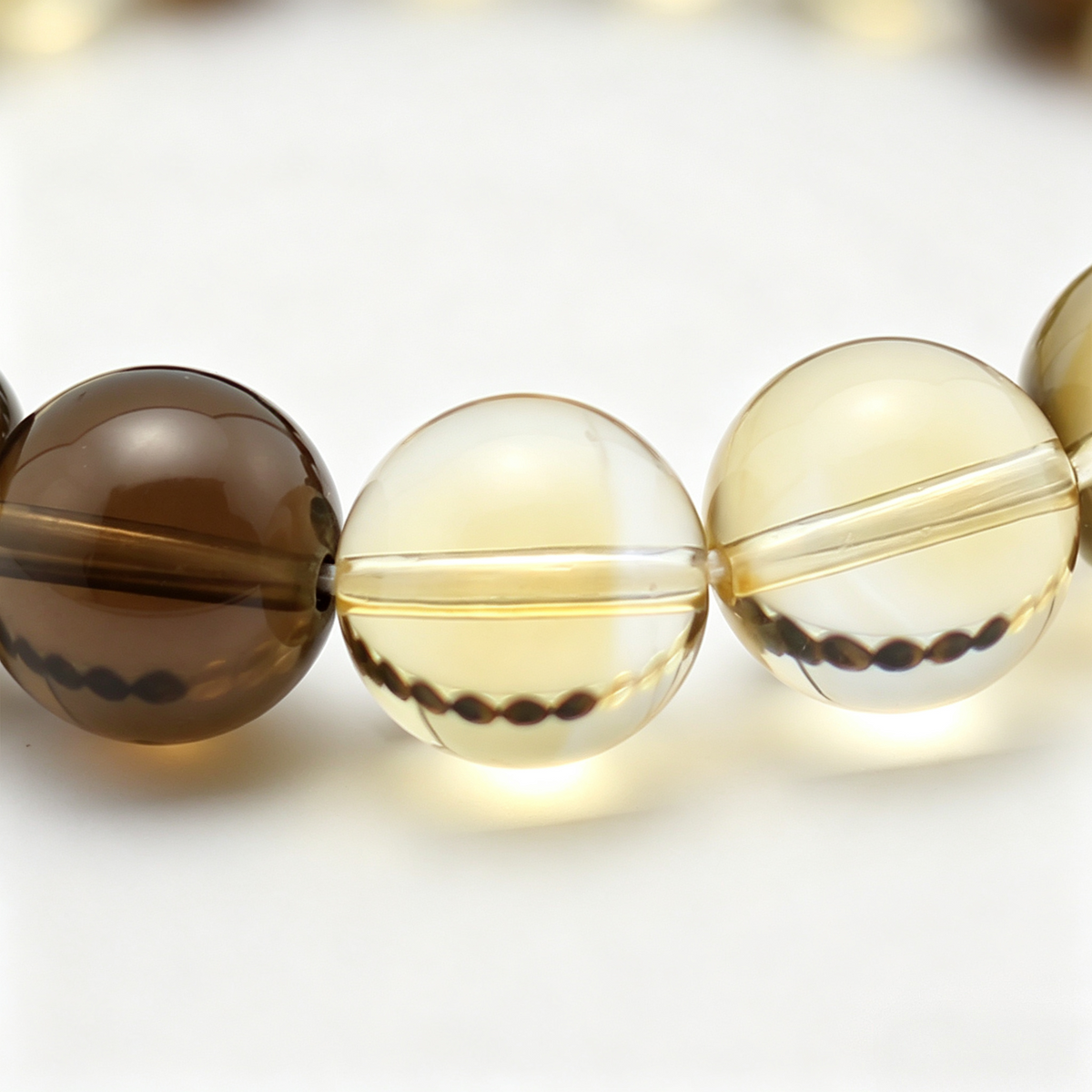 Bedrock bead detail — tiger's eye, citrine and smoky quartz, natural markings up close.
