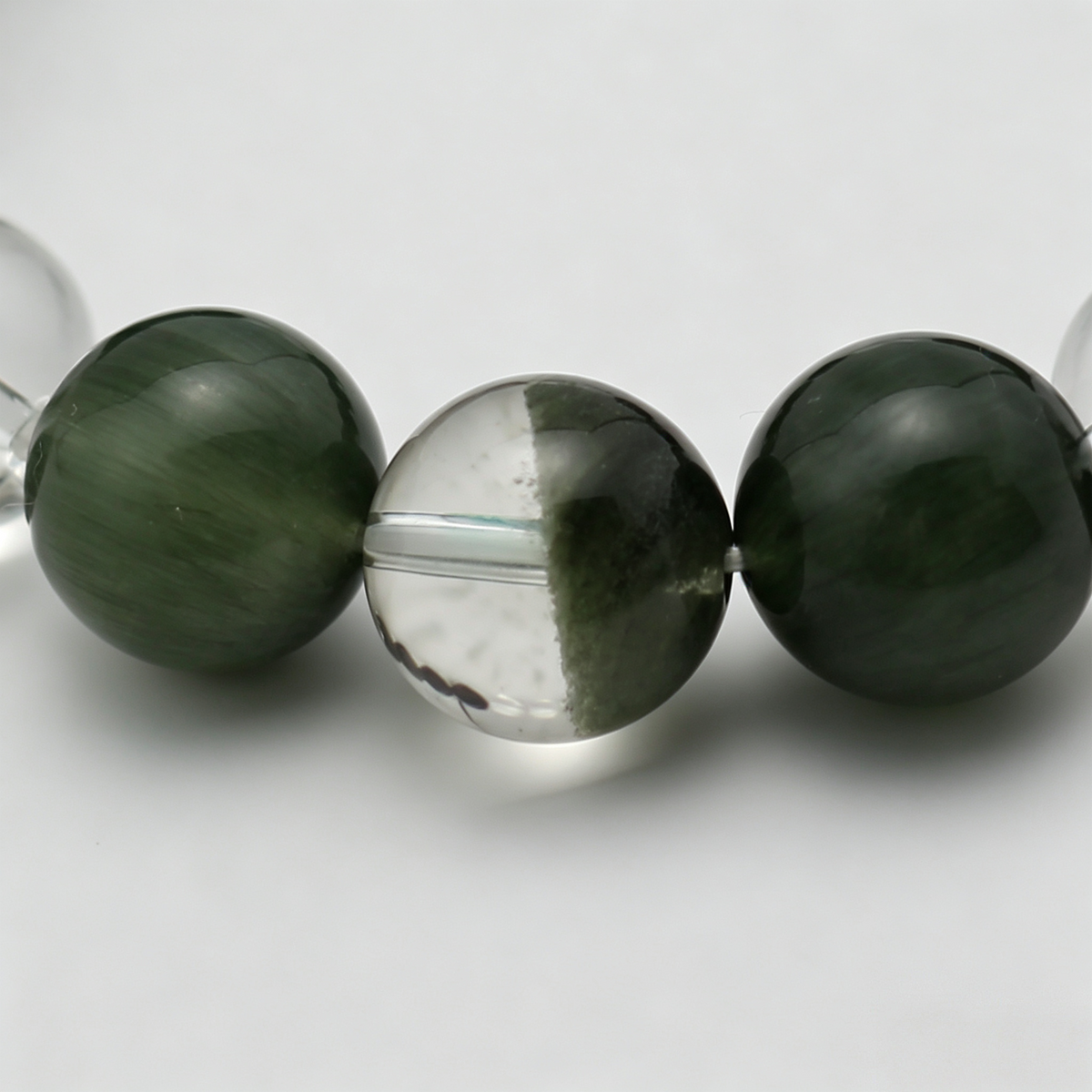Close-up of the Golden Channel bracelet by Krysora - bead detail, silver sheen obsidian, clear quartz, green rutilated and green phantom, natural markings