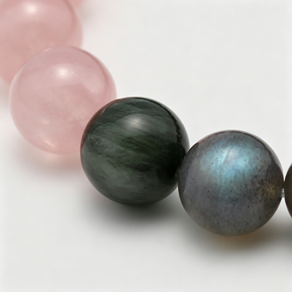 Close-up of the Aqua Ember bracelet by Krysora - bead detail, golden sheen obsidian, rose quartz, green rutilated quartz, natural markings
