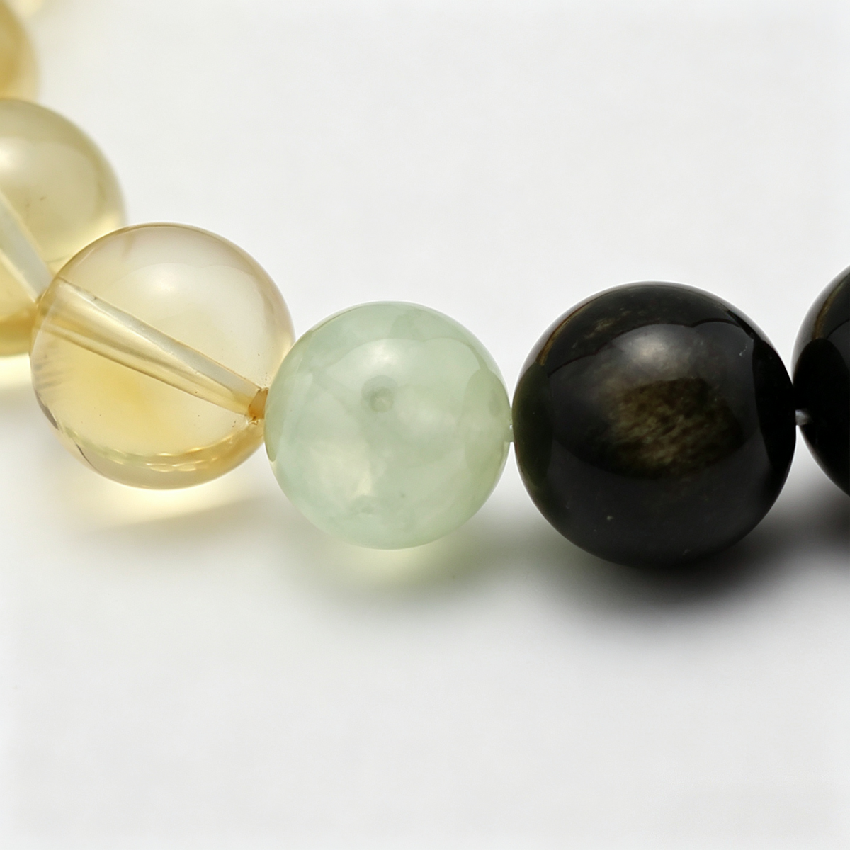 Close-up of the Tri-Flourish bracelet by Krysora - bead detail, black obsidian with golden sheen, natural markings