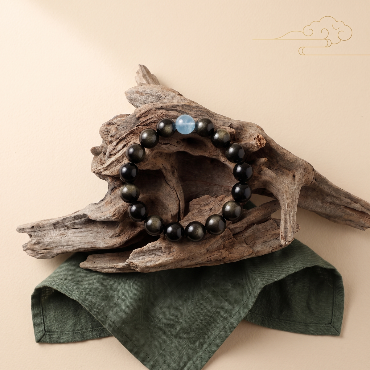 Aqua Sheen bracelet by Krysora in a brand scene -- sea-blue aquamarine and gold sheen obsidian beads, styled in natural daylight.